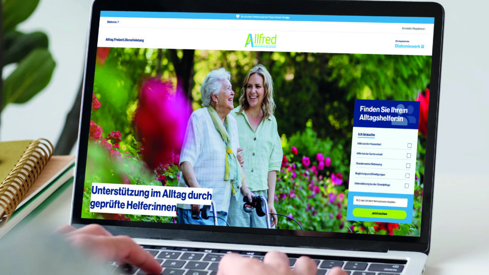 Laptop mit Händen, auf dem Bildschirm die Allfredplattform
